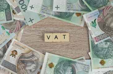 VAT is value added tax. Flat lay with Polish złoty money, PLN zloty banknotes. Rising economics inflation in Poland concept. Government anti-inflation shield tax cut, reduced VAT on some products.
