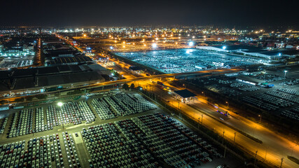 Fototapeta na wymiar night scene shot over lighting new cars lined up at Industrial factory and commercial port