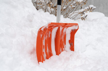 Shovel for removing snow from the sidewalk on a cold winter day. Snow shoveling or clearing, removal after snowstorm.