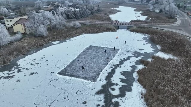 Irresponsible people playing hockey on a frozen lake. Very risky activity.