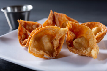 A closeup view of plate of cream cheese wontons.