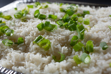 A closeup view of a catering tray of steamed white rice.