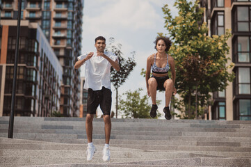 Two sportspeople performing the high jumps outdoors