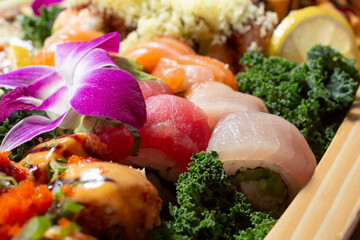 A closeup view of a a variety of sushi pieces, featuring rolls and nigiri.