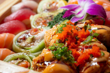 A closeup view of a variety of sushi pieces, featuring rolls and nigiri.
