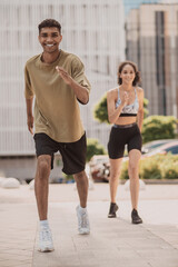 Sporty young man and a girl performing an aerobic exercise