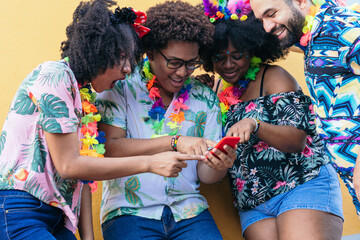 Latin friends laughing and using cell phones in Carnival