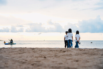 Children in white standing on the beach with copy space