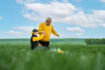 Happy family active outdoor games. Grandfather and grandson fly a kite. Healthy life concept. High quality photo