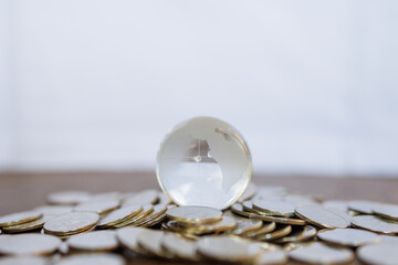 Global Business and Financial, Economic and palnning Concept. Close up of clear glass mini world ball on pile of coins with copy space.