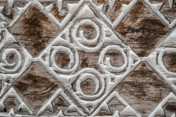 Balinese wood carving. A pattern of curls on the aged wood surface.