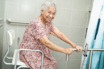 Asian elderly woman patient use toilet bathroom handle security in nursing hospital ward, healthy...