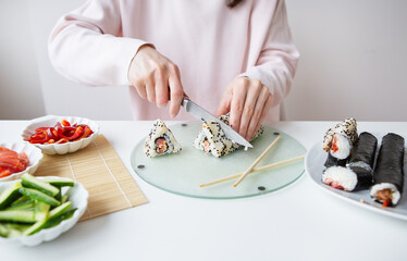The process of making sushi, the girl makes sushi with different flavors - fresh salmon, caviar,...