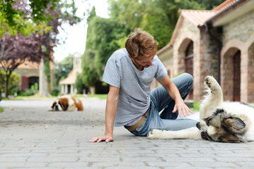 Handsome adult is playing with his dog outdoors. Saint Bernard enjoys company of his human.