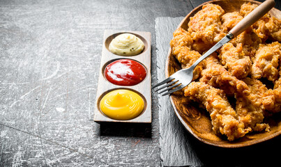 Chicken strips with different sauces.