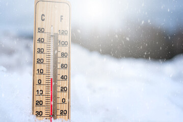 Thermometer in the snow. Winter thermometer. Low temperatures in celsius or fahrenheit.