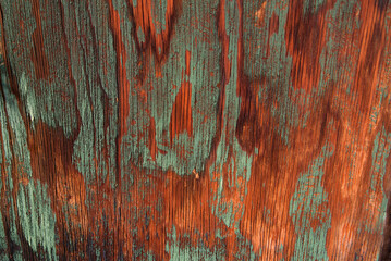 Close up of weathered old wood on a mountain cabin, with colors of green and red-orange forming an abstract pattern.