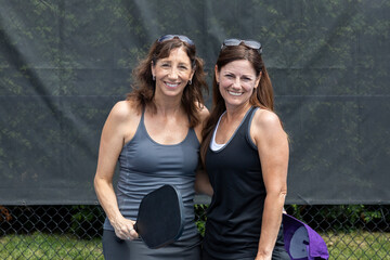 Two pickleball players posing with paddles