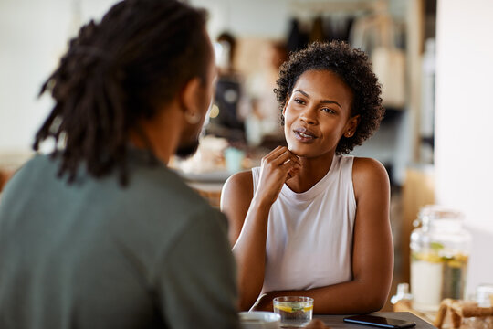 Young woman talking with her boyfriend over drinks