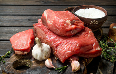 Raw meat. Pieces of fresh beef with garlic and spices.