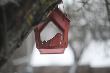 Close-up of a bird feeder on a tree under the snow in the forest.