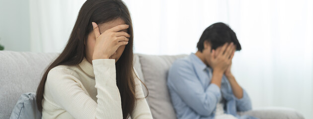 Family problems, Asian women cover her face and sit separately from husband feel disappointed after quarrels at home.