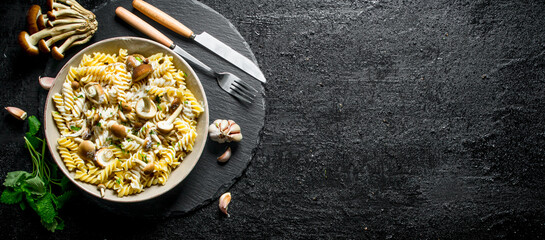 Fusilli paste in plate with mushrooms, garlic and mint leaves.