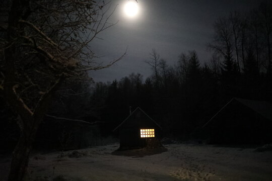 Landscape with house at night under dark sky with full moon. Spooky landscape with house in night.