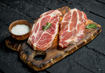 Raw pork steaks with aromatic and herbs and spices.