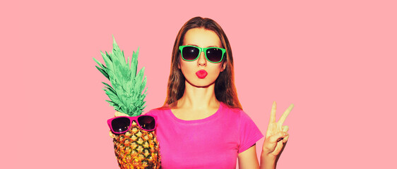 Fashion portrait of young woman in sunglasses with pineapple on pink background
