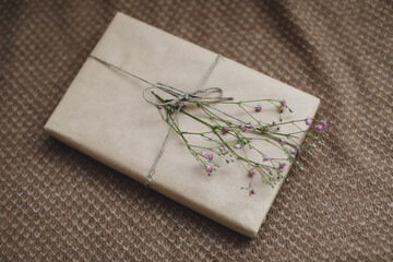  a gift box in craft paper decorated with a flower