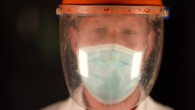 Australian person putting on safety equipment and a mask in a workplace in an industry