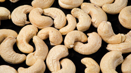 Many Cashew Nuts on Black Background. Camera above Nuts