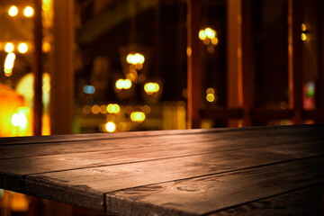 image of a wooden table in front of an abstract blurred background of golden lights
