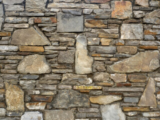 Rough stone wall texture background. Old and weathered surface.
