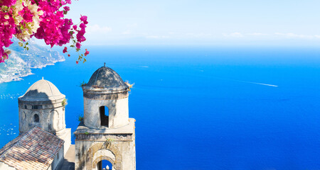 Two belltowers with flowers and sea in Ravello village, Amalfi coast of Italy, web banner format