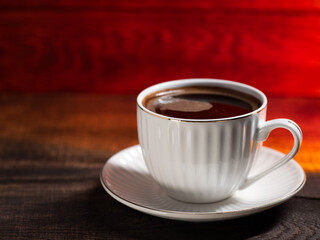 white cup of hot coffee on a wooden table copy space