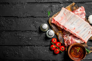 Raw ribs on wooden board
