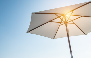 Luxury umbrella in the sun against blue sky. Hot summer relaxation and vacation concept. - obrazy, fototapety, plakaty