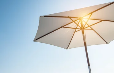 Fotobehang Luxury umbrella in the sun against blue sky. Hot summer relaxation and vacation concept. © Nancy Pauwels