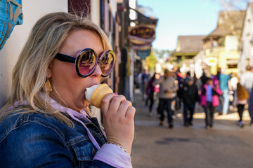 Woman eats an ice cream cone on the streets of St. Augustine, Florida