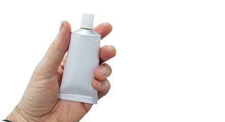 Hand holding a tube of ointment on white background