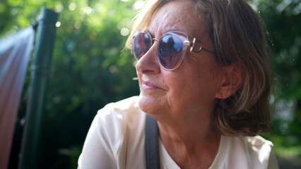 older woman wearing big sunglasses outside