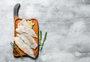 Fish fillet with lemon slices, thyme and rosemary.