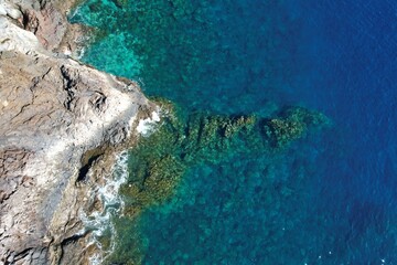 Fototapeta premium Blue ocean with clear underwater seascape near the volcanic coast of El Hierro, Canary Islands, Spain. Top view aerial shot.
