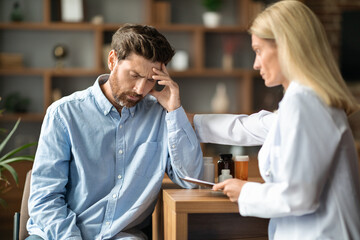Bad Diagnosis. Doctor Lady Comforting Depressed Male Patient During Appointment In Clinic