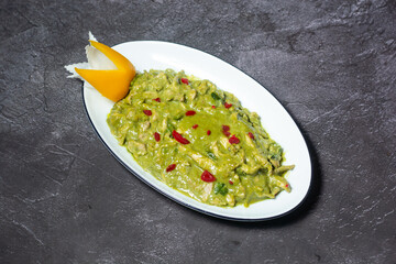 Green chicken Curry served in dish isolated on grey background top view of indian and bangladesh food