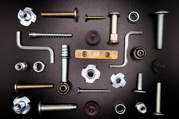 Furniture fittings. Furniture assembly hardware options and tools on a black background. Large...