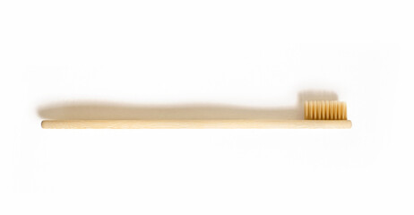 Bamboo toothbrush on a white isolated background. Eco-friendly plastic-free toothbrush. Free space for text. Waste-free personal care products, dental care concept