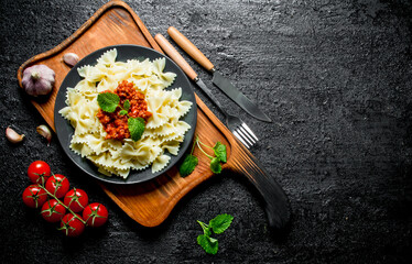 Pasta Farfalle with Bolognese sauce on plate and cherry tomatoes.